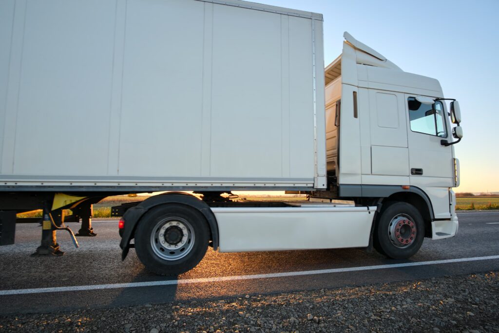 Vrachtwagenchauffeur achter het stuur op weg naar keuring voor groot rijbewijs verlengen.